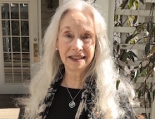 Louise Hawes ’65 standing in front of her home.
